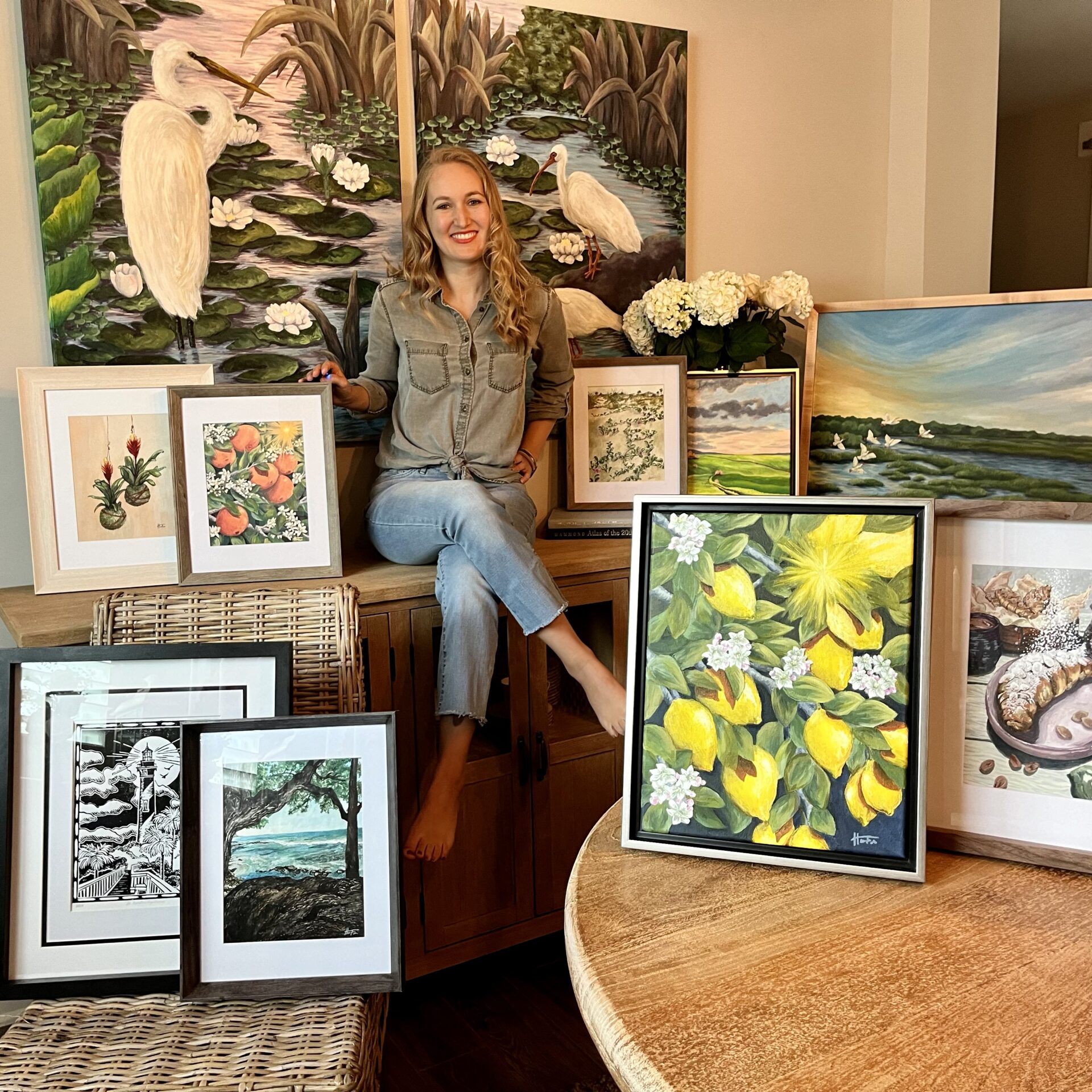 Heather surrounded by 11 of her paintings