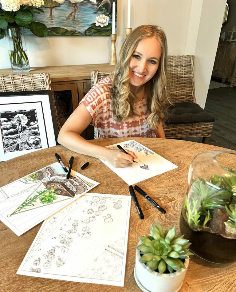 Heather smiling and drawing a coloring page with ink pens